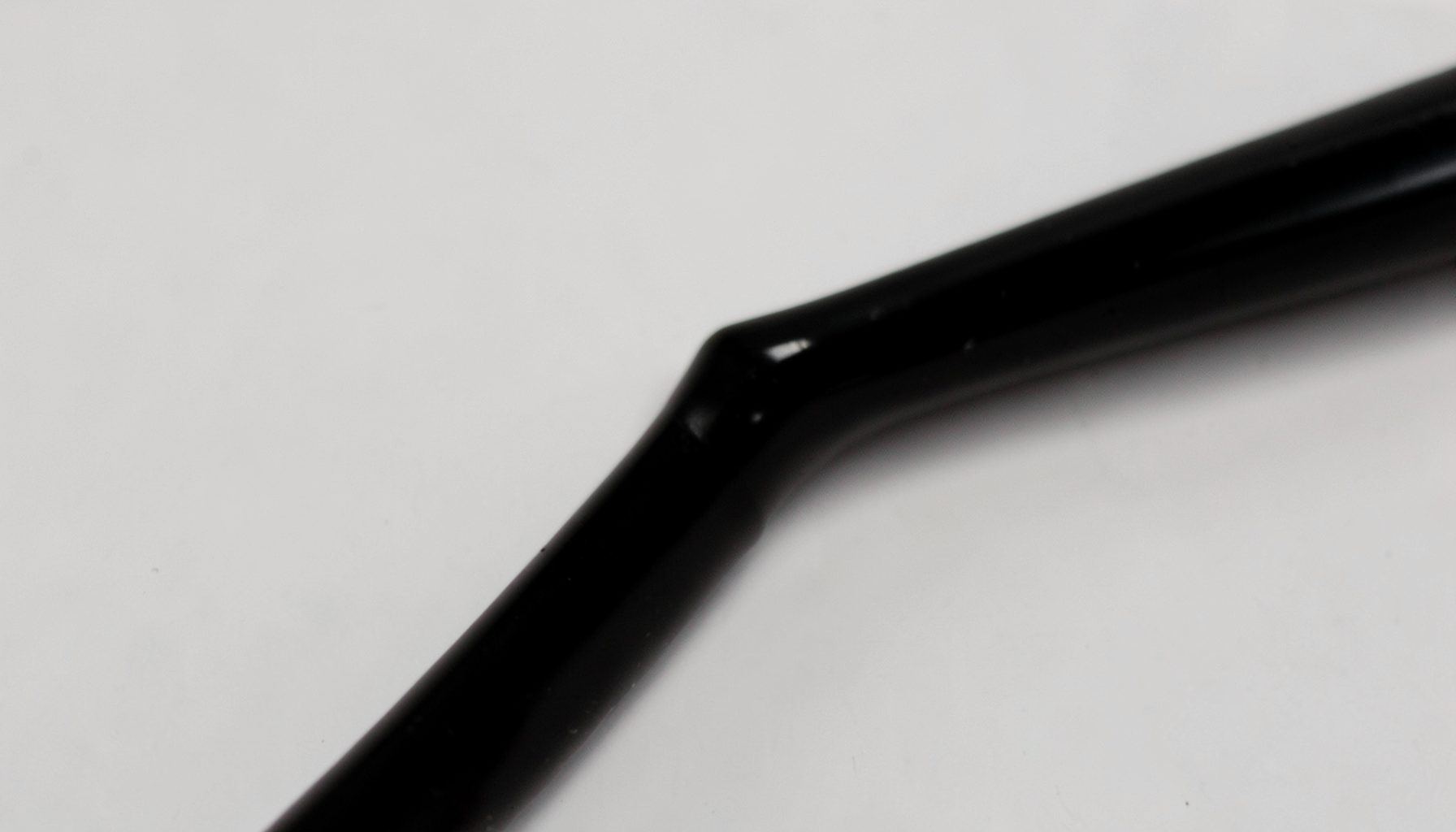 Delineador em gel preto com pincel fino sobre fundo neutro, traço preciso em close, estilo editorial de beleza